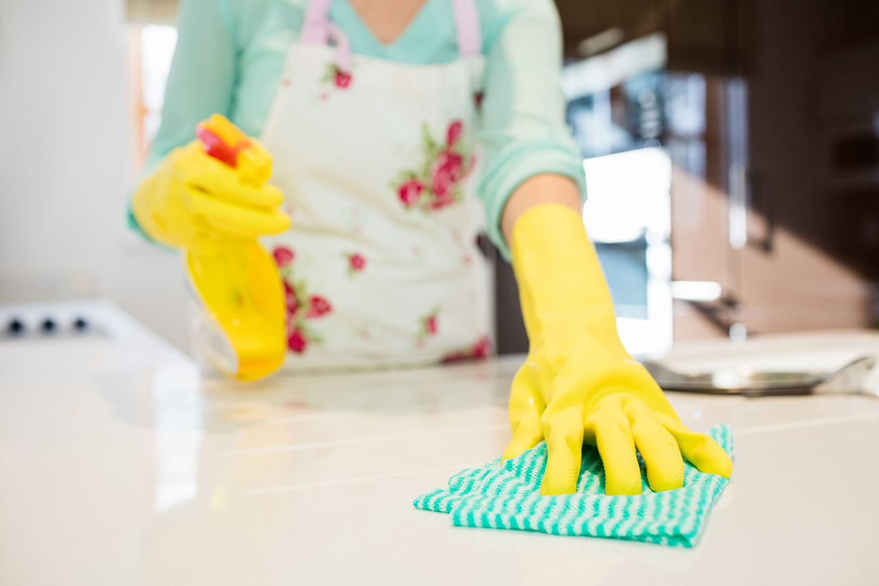 Close-up of woman cleaning kitchen worktop at home